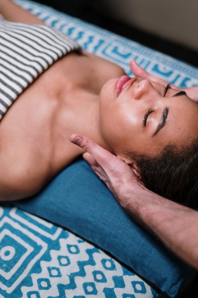woman-lying-on-blue-textile-3997993 Indulge in a calming facial massage in a luxury spa setting, promoting relaxation and wellness.